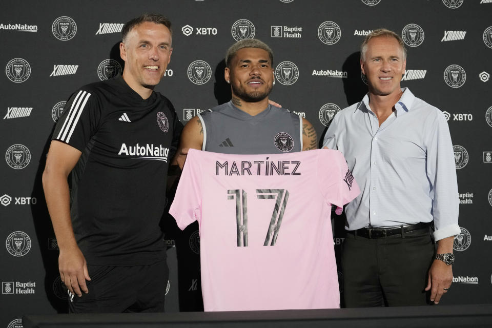 Venezuelan striker Josef Martinez, center, holds an Inter Miami soccer jersey as he poses for a photograph with head coach Phil Neville, left and Chief Sporting Director Chris Henderson, right, during a news conference at the Inter Miami soccer stadium, Wednesday, Jan. 18, 2023, in Fort Lauderdale, Fla. Martinez signed as a free agent with the MLS Inter Miami soccer team after playing for Atlanta United. (AP Photo/Lynne Sladky)