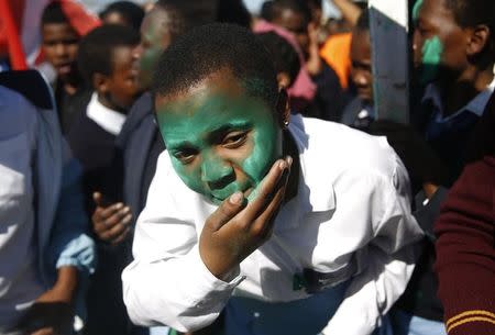 A protester covers her face with green powder in remembrance of one of the leaders of the Marikana mineworkers, during a march to commemorate the second anniversary of the killing of striking Marikana mineworkers in Cape Town's Philippi township August 16, 2014. REUTERS/Mike Hutchings