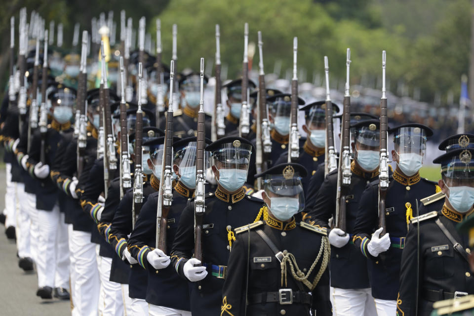 Honor guards march during the state burial rites of former Philippine President Benigno Aquino III on Saturday, June 26, 2021 at a memorial park in suburban Paranaque city, Philippines. Aquino was buried in austere state rites during the pandemic Saturday with many remembering him for standing up to China over territorial disputes, striking a peace deal with Muslim guerrillas and defending democracy in a Southeast Asian nation where his parents helped topple a dictator. He was 61. (AP Photo/Aaron Favila)