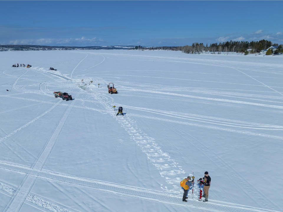 This photo provided by Aroostook UAS shows volunteers creating a giant ice carousel on a frozen lake work on a path curt through the ice on Wednesday, March 29, 2023 on Long Lake in Madawaska, Maine. (Aroostook UAS via AP)