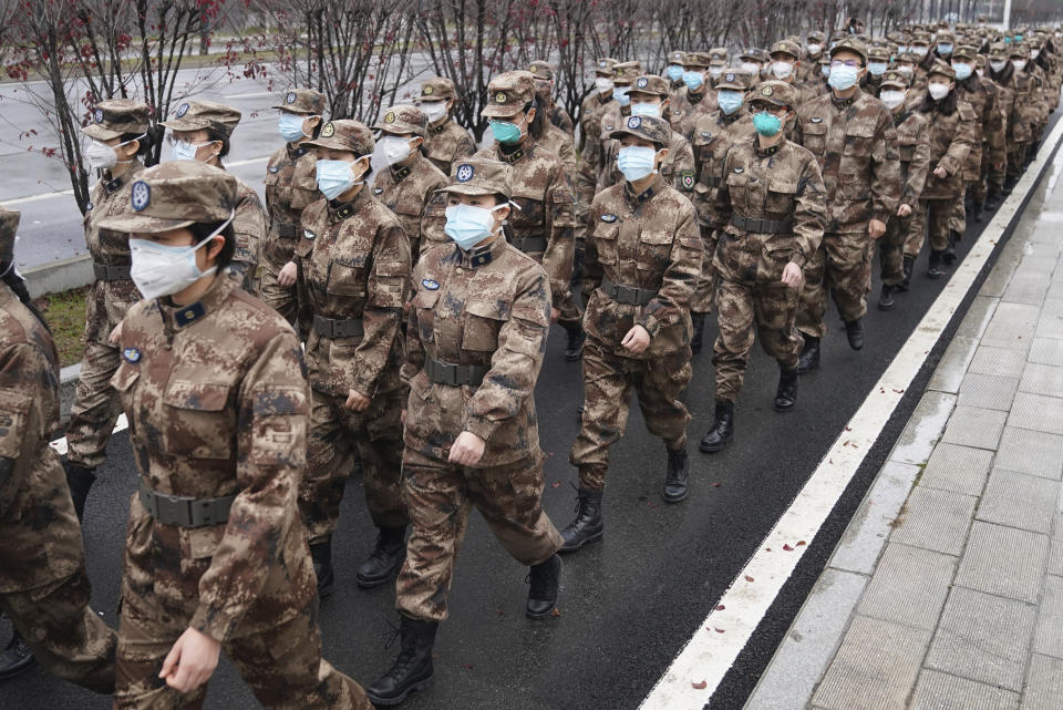 In this Jan. 26, 2020, photo released by Xinhua News Agency, members of a military medical team head for Wuhan Jinyintan Hospital in Wuhan, central China's Hubei province. China on Monday expanded sweeping efforts to contain a viral disease by postponing the end of this week's Lunar New Year holiday to keep the public at home and avoid spreading infection. (Cheng Min/Xinhua via AP)