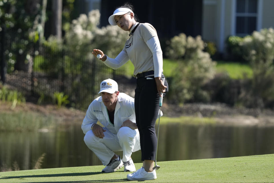 Amy Yang, of South Korea, right, lines up a putt on the 11th green with her caddie Jan Meierling, left, during the final round of the LPGA CME Group Tour Championship golf tournament, Sunday, Nov. 19, 2023, in Naples, Fla. (AP Photo/Lynne Sladky)