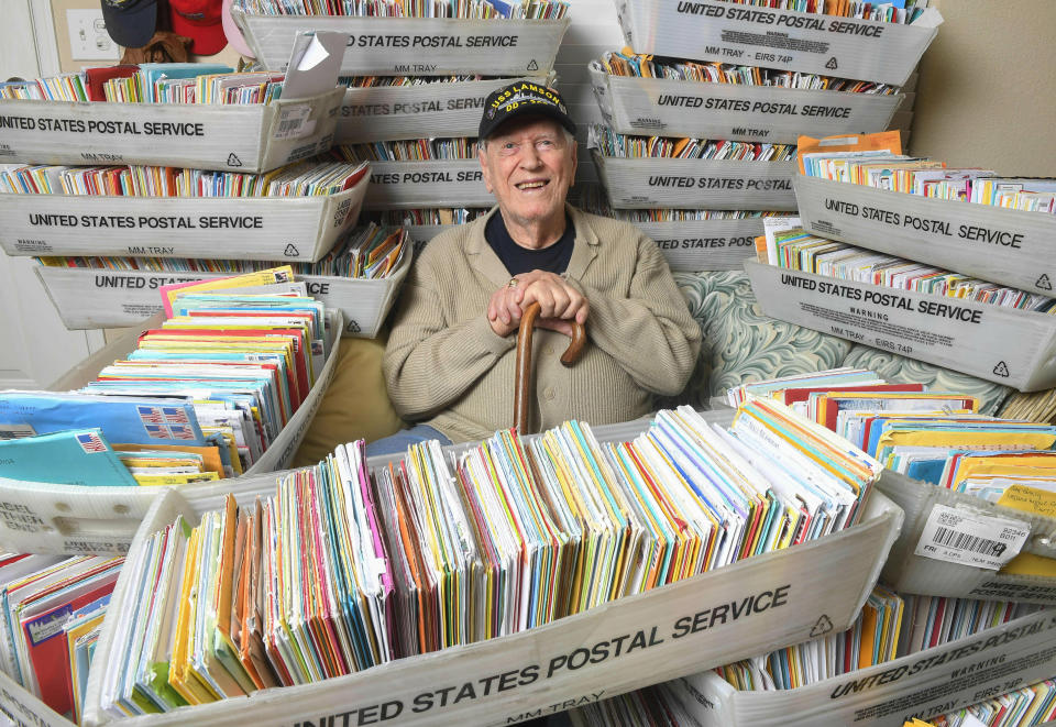 In this Tuesday, Jan. 8, 2019 photo, Duane Sherman, 96, poses at home with a small fraction of the 50,000 birthday cards he's received after his daughter's social media request for people to send him cards to cheer him up on his birthday went viral in Fullerton, Calif. (Kevin Sullivan/The Orange County Register via AP)