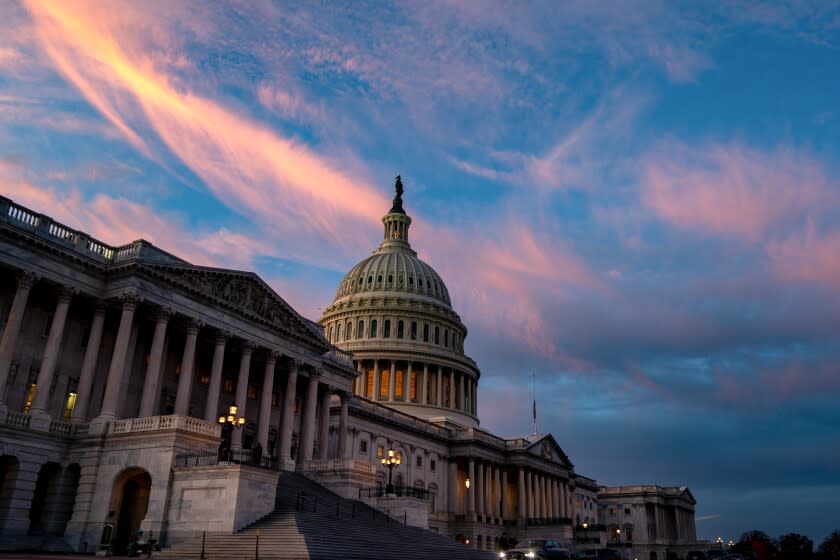 The sun sets, casting an orange glow in the sky behind the U.S. Capitol Building on Tuesday, Dec. 7, 2021 in Washington, DC.