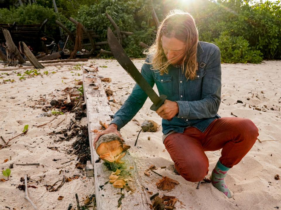 Tyson Apostol cutting a coconut on survivor