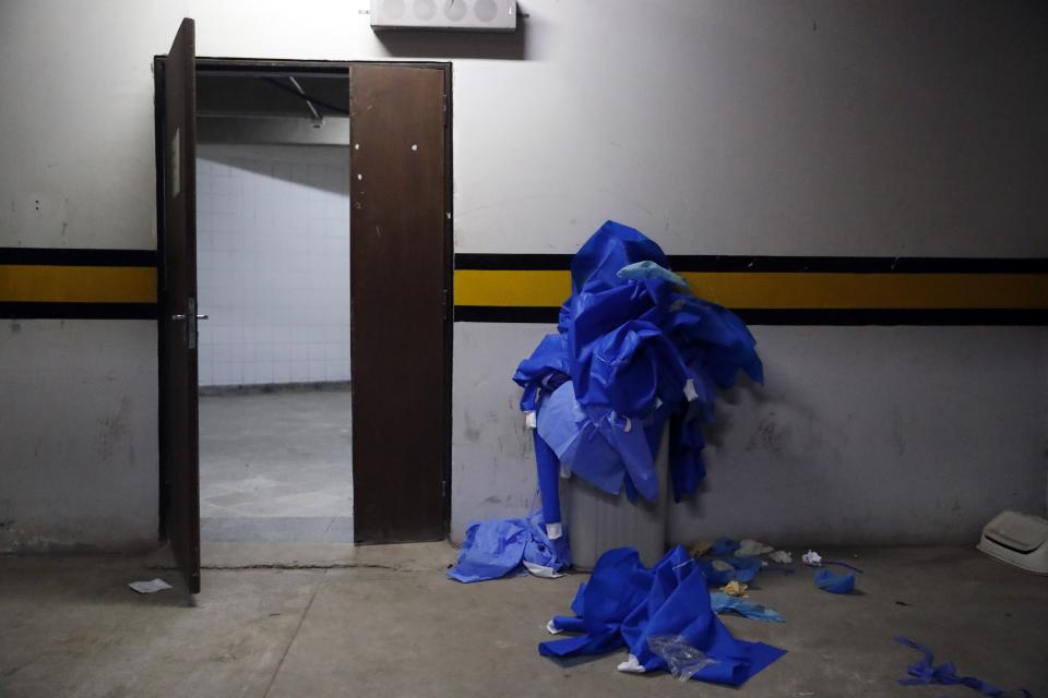 Used security gear worn in the COVID-19 area overflows a trash can at Clinicas Hospital in San Lorenzo, Paraguay, Tuesday, April 20, 2021. (AP Photo/Jorge Saenz)