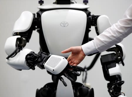 An employee of Toyota Motor Corp. demonstrates T-HR3 humanoid robot which will be used to support the Tokyo 2020 Olympic and Paralympic Games, during a press preview in Tokyo