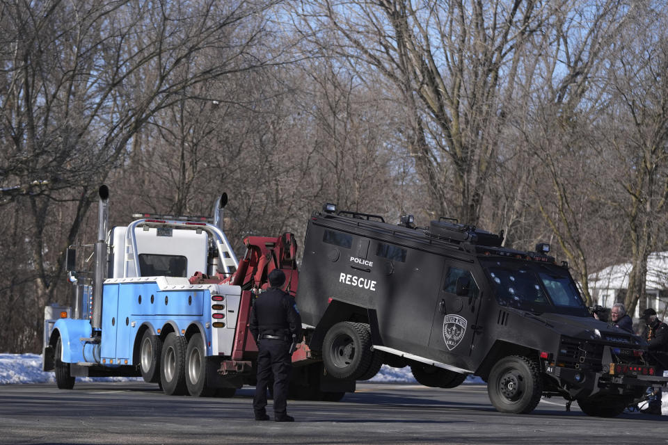 A police vehicle with what appears to be bullet pockmarks is towed near the scene where two police officers and a first responder were shot and killed Sunday, Feb. 18, 2024, in Burnsville, Minn. (AP Photo/Abbie Parr)