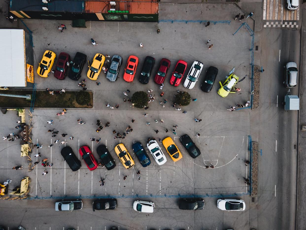 76 Car Trivia Questions. Pictured: a drone shot of a parking lot filled with sports cars.