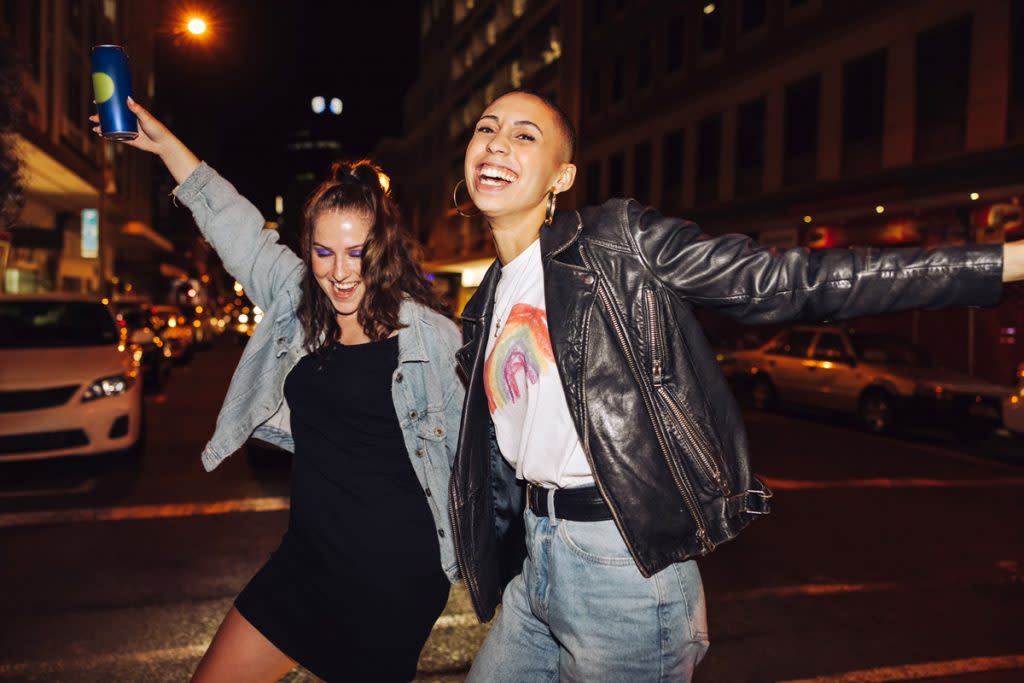 Two women dance in the street. 