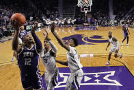 TCU forward Xavier Cork (12) shoots over Kansas State forwards David N'Guessan (3) and Nae'Qwan Tomlin (35) during the first half of an NCAA college basketball game Tuesday, Feb. 7, 2023, in Manhattan, Kan. (AP Photo/Charlie Riedel)