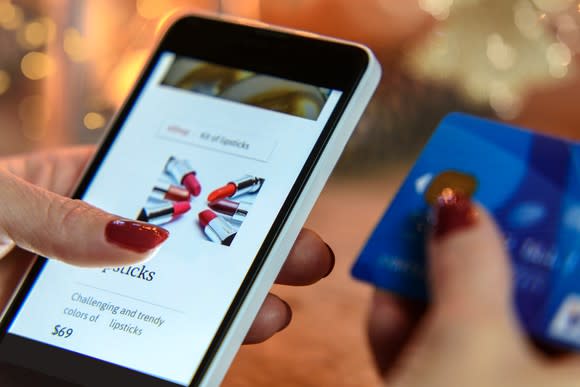 Woman shopping on a smartphone while holding a credit card