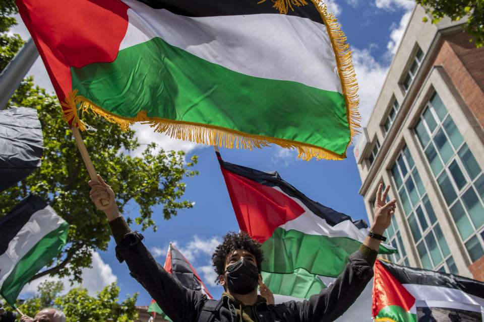 Protesters shout slogans and wave Palestinian flags in support of Palestinians during the latest round of violence, outside the Israeli embassy in Madrid, Spain, Tuesday, May 11, 2021. (AP Photo/Manu Fernandez)