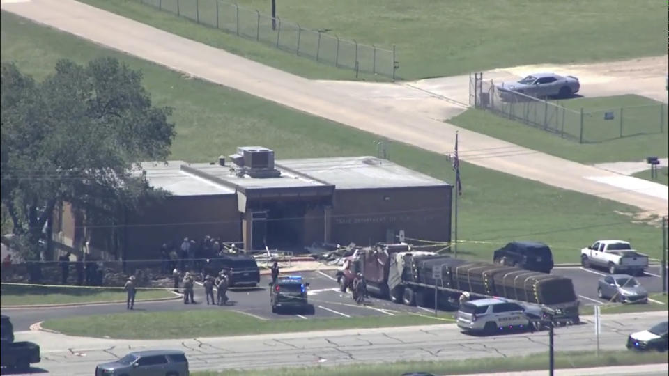 Emergency personnel arrive on the scene after a an 18-wheeler crashed into the Texas Department of Public Safety Office in Brenham, Texas on Friday, April 12, 2024. A suspect is in custody in connection to a commercial vehicle crash at the Texas Department of Public Safety office in the rural town west of Houston. Texas DPS officials say multiple injuries were reported in the crash. (KTRK via AP)