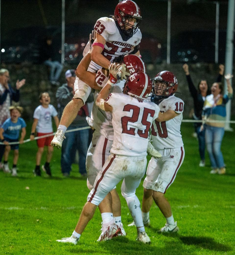 Westborough High School senior Camden Petralia is hoisted into the air after scoring the game winning two point conversion in overtime, defeating Marlborough, 29-27, at Kelleher Field, Oct. 27, 2023.