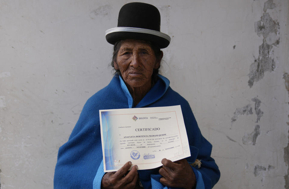 Anacleta Mamani Quispe, 71, poses for a photo after receiving her certificate during an adult literacy graduation ceremony in Pucarani, Bolivia, Sunday, Dec. 4, 2022. Mamami is among more than 20,000 senior citizens, mainly women from low-income rural communities, who have learned to read and write this year as part of “Bolivia Reads,” a government-sponsored literacy program. (AP Photo/Juan Karita)