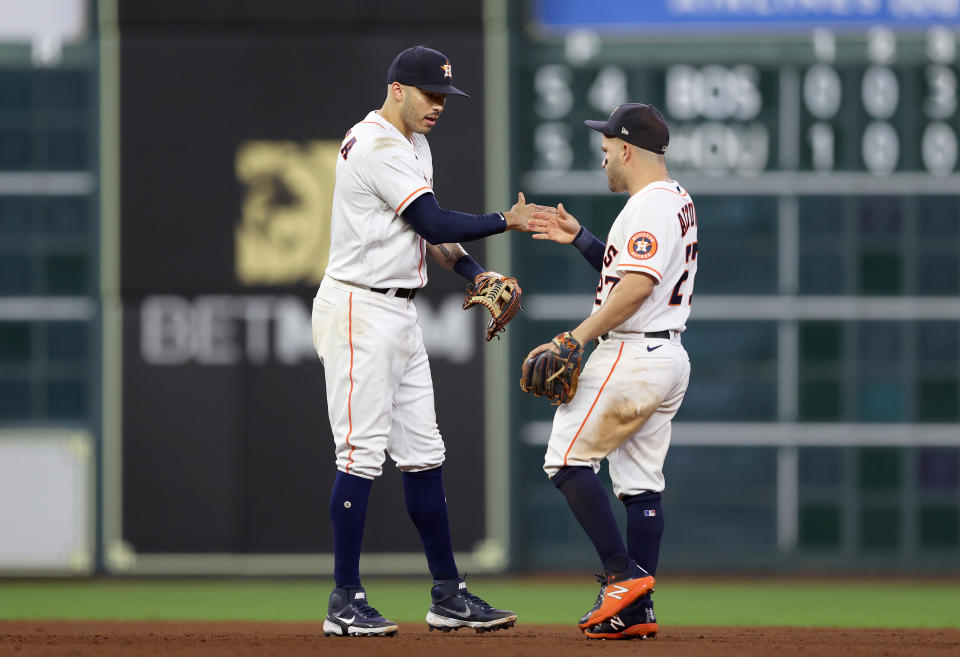 HOUSTON, TEXAS - OCTOBER 15:  Carlos Correa #1 and Jose Altuve #27 of the Houston Astros shake hands after they beat the Boston Red Sox in Game One of the American League Championship Series at Minute Maid Park on October 15, 2021 in Houston, Texas. (Photo by Elsa/Getty Images)