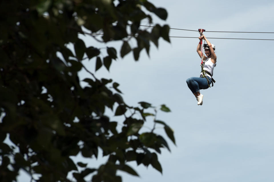 LONDON, ENGLAND - JULY 18:  A woman rides the Zip World zip wire over Archbishop's Park on July 18, 2017 in London, England. The zip wire is 35 metres high at its highest point and 225 metres-long making it the world's biggest and fastest city-centre zip line.  (Photo by Carl Court/Getty Images)