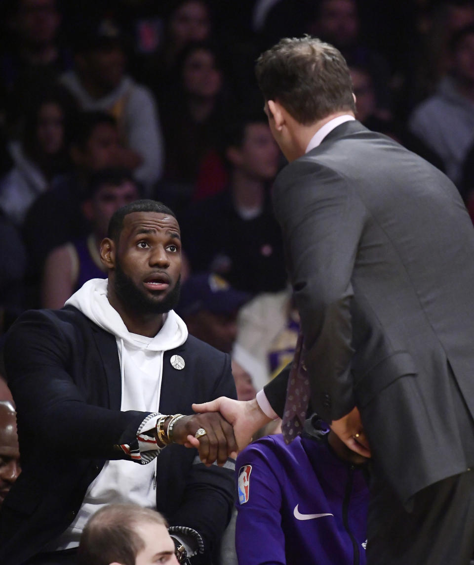 Los Angeles Lakers forward LeBron James, left, shakes hands with coach Luke Walton as they have a chat during the first half of an NBA basketball game against the Los Angeles Clippers on Friday, Dec. 28, 2018, in Los Angeles. (AP Photo/Mark J. Terrill)