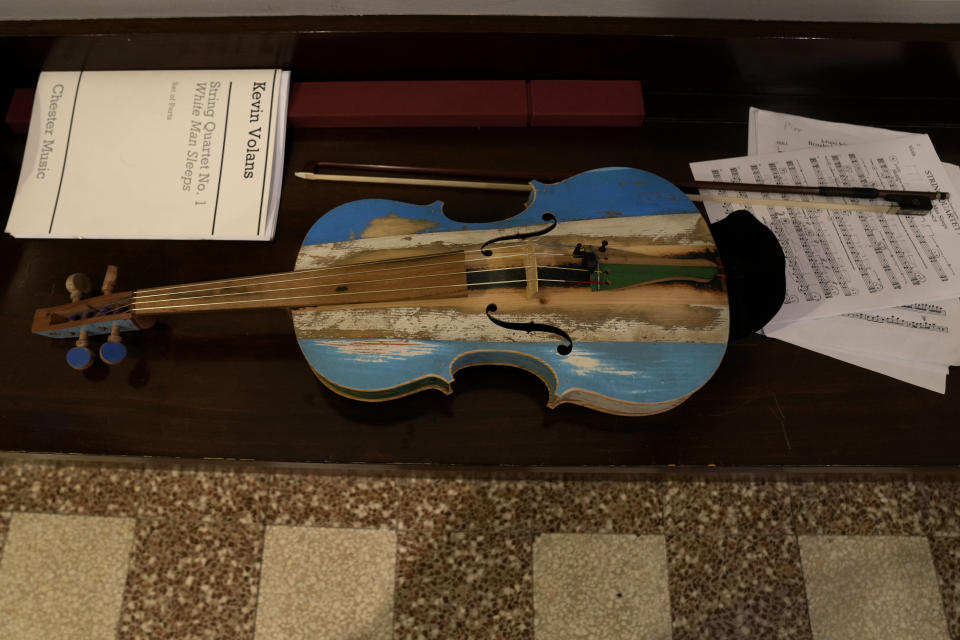 A violin made from the wood of wrecked immigrants' boats is seen during a rehearse in Milan, northern Italy, Saturday, Feb. 10, 2024. Inmates at Milan's maximum security prison Opera took the wood of wrecked boats sailed by migrants across the Sicily Channel to craft the musical instruments that the 'Sea Orchestra' used during their debut at La Scala Opera House in Milan on Monday, Feb. 12, 2024. The violins, violas and cellos played by the Orchestra of the Sea in its debut performance Monday at Milan's famed Teatro all Scala carry with them tales of hardship. (AP Photo/Antonio Calanni)