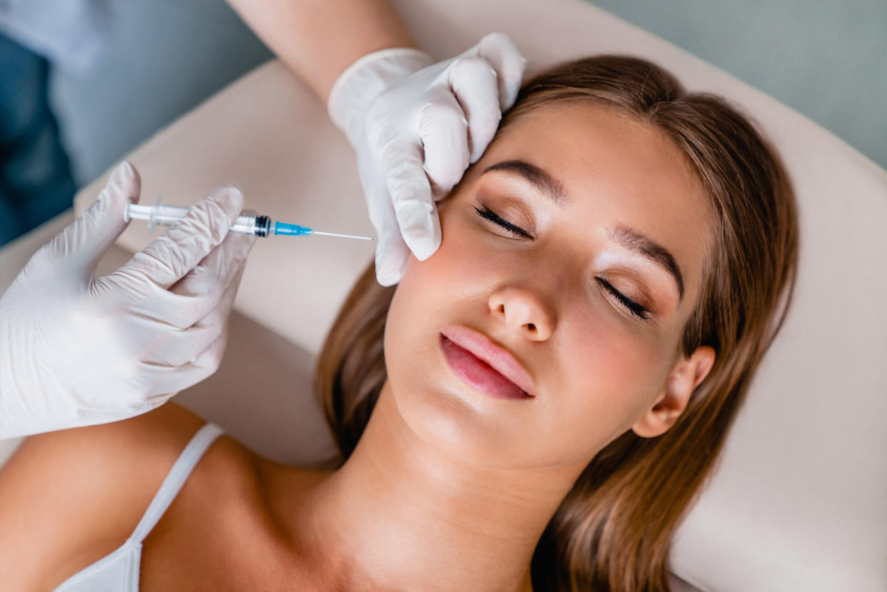 Young woman gets beauty facial injections in salon�