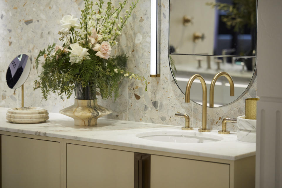 A beige bathroom cabinet with white counter top and tiled backsplash