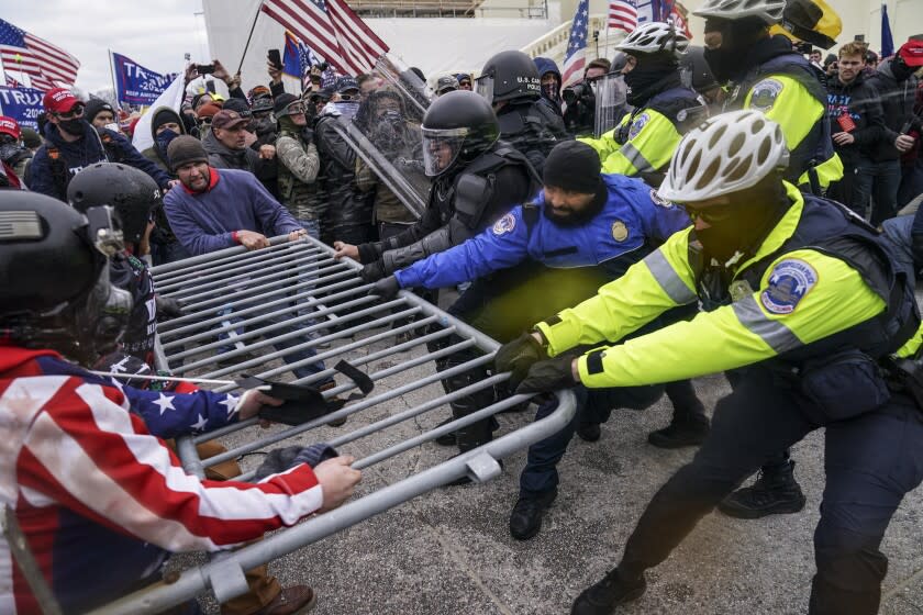 ARCHIVO - Partidarios violentos de Donald Trump tratan de rebasar una barrera policial en el Capitolio en Washington el 6 de enero del 2021. (AP Foto/John Minchillo)