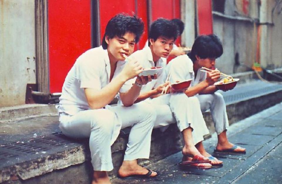 林志成（左1）18歲在蓮園餐廳當廚師，下班後與同事坐在路邊吃飯。（林志成提供）