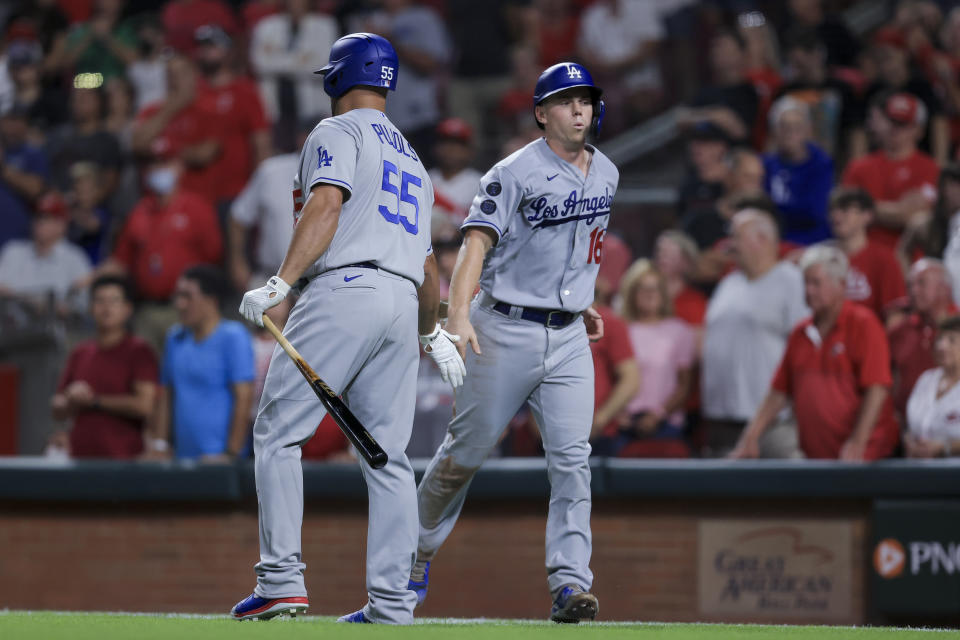 Los Angeles Dodgers' Will Smith, right, slaps hands with Albert Pujols after scoring a run during the ninth inning of the team's baseball game against the Cincinnati Reds in Cincinnati, Friday, Sept. 17, 2021. The Reds won 3-1. (AP Photo/Aaron Doster)