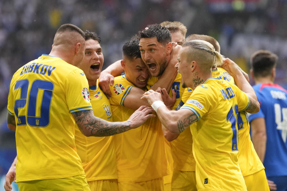 El ucraniano Roman Yaremchuk celebra con sus compañeros tras anotar el segundo gol en el encuentro ante Eslovaquia en el Grupo E de la Euro 2024 el viernes 21 de junio del 2024. (AP Foto/Andreea Alexandru)