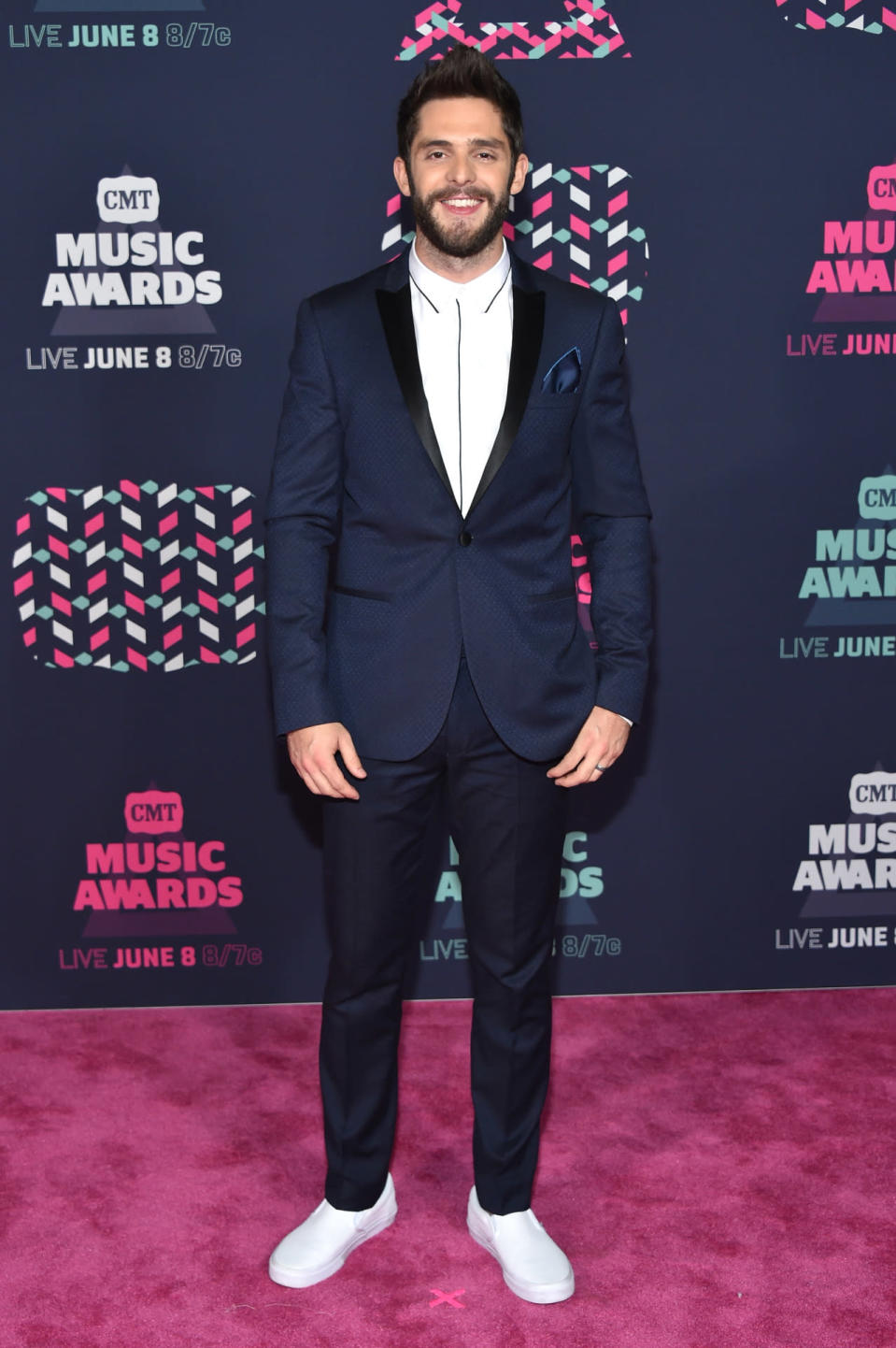 Thomas Rhett back at it again in a navy blue suit with white Vans 