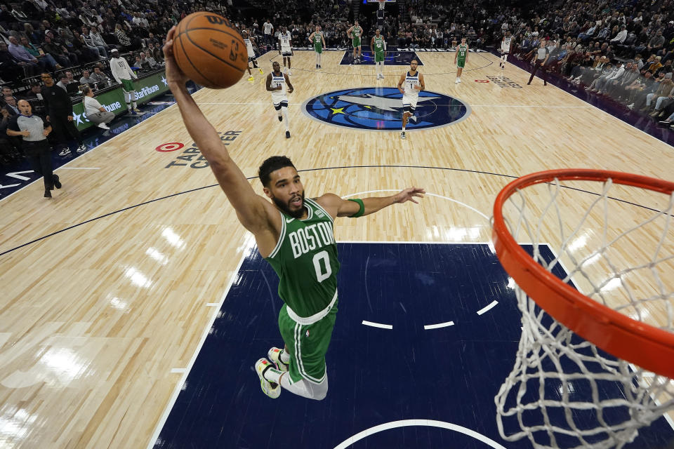 Boston Celtics forward Jayson Tatum (0) goes up for a dunk during the first half of an NBA basketball game against the Minnesota Timberwolves, Monday, Nov. 6, 2023, in Minneapolis. (AP Photo/Abbie Parr)