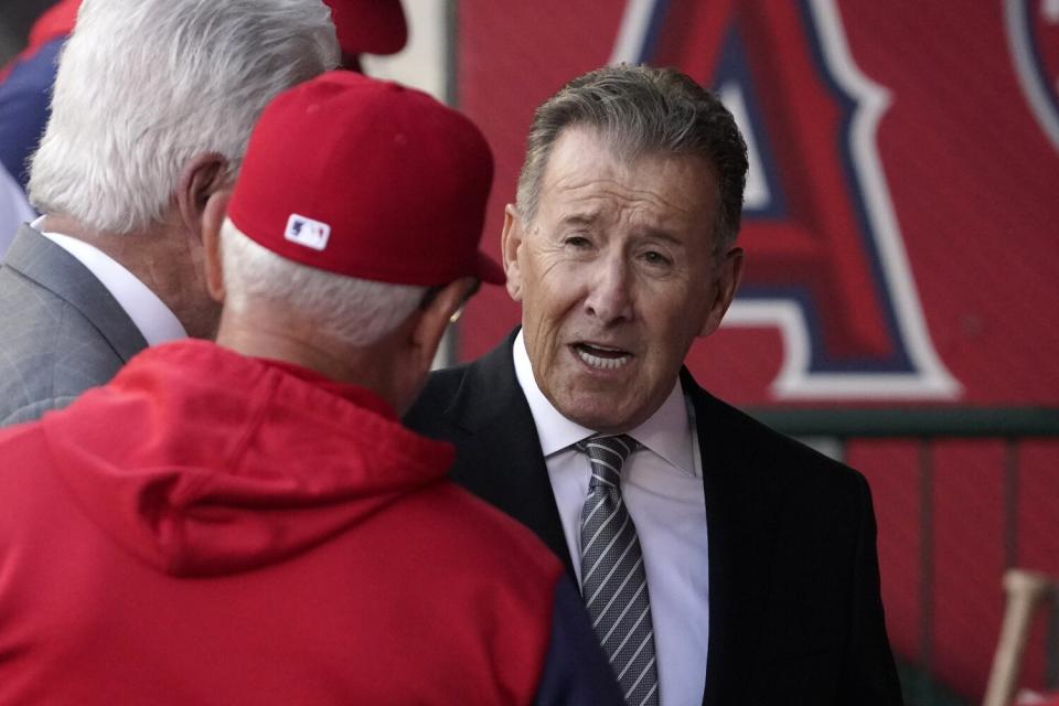 Angels owner Arte Moreno, right, talks with Angels manager Joe Maddon before a game.