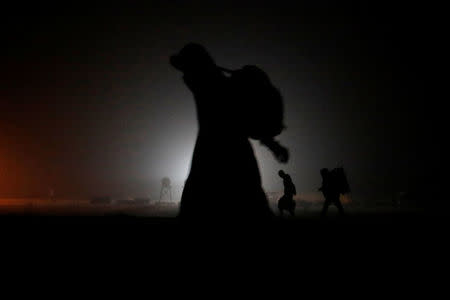 A group of migrants who said they were from Djibouti and Somalia walk along railway tracks after crossing the Canada-U.S. border in Emerson, Manitoba, Canada, March 27, 2017. REUTERS/Chris Wattie