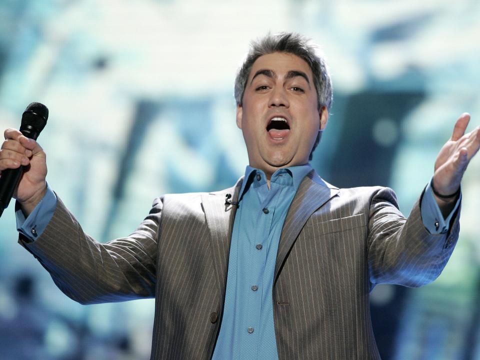 Taylor Hicks outstretches his arms and looks surprised on "American Idol" stage