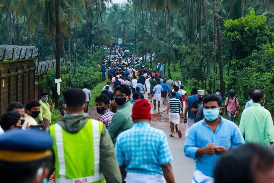 People gather to watch the wreckage of an Air India Express jet at Calicut International Airport in Karipur, Kerala, on August 8, 2020. - Fierce rain and winds lashed a plane carrying 190 people before it crash-landed and tore in two at an airport in southern India, killing at least 18 people and injuring scores more, officials said on August 8. (Photo by Arunchandra BOSE / AFP) (Photo by ARUNCHANDRA BOSE/AFP via Getty Images)