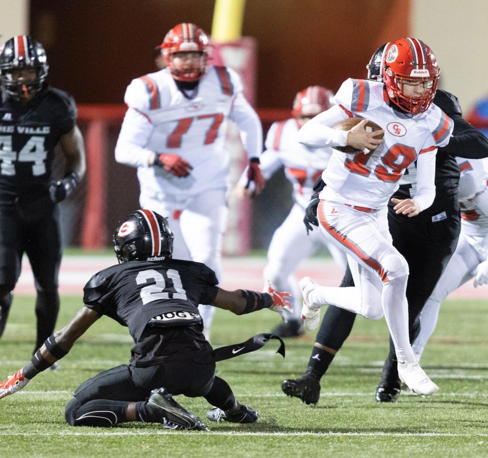 Canton South quarterback Poochie Snyder eludes the tackle of Glenville defender Demetrius Harper in the first half during the OHSAA high school football playoffs at Wadsworth High School Friday, November 24, 2023.