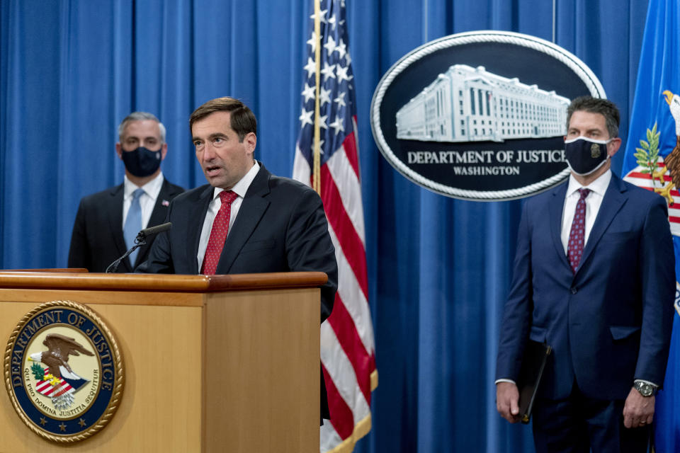 Assistant Attorney General for the National Security Division John Demers, second from left, accompanied by U.S. Attorney for the Western District of Pennsylvania Scott Brady, left, and FBI Deputy Director David Bowdich, right, speaks at a news conference at the Department of Justice, Monday, Oct. 19, 2020, in Washington. (AP Photo/Andrew Harnik, pool)