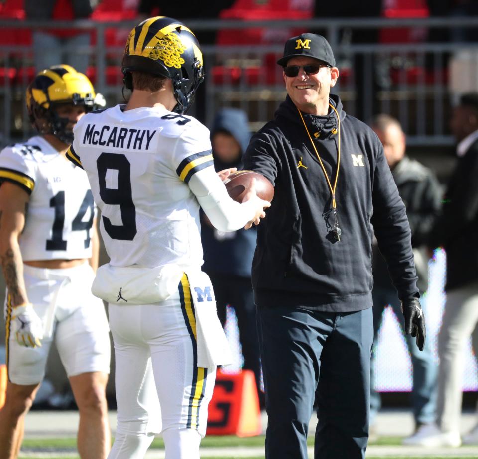 Michigan coach Jim Harbaugh and quarterback J.J. McCarthy on the field before the game against Ohio State in Columbus, Ohio, on Saturday, Nov. 26, 2022.
