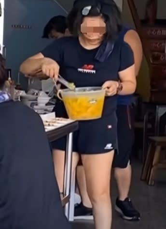 台南一間知名的蝦仁飯老闆娘，在夾菜時沒戴口罩。（圖／東森新聞）