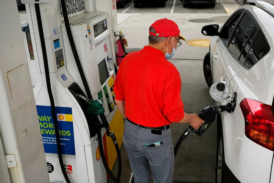 A worker fills up a car with gas outside the Holland Tunnel at the start of the Memorial Day weekend, under rising gas prices and record inflation, in Newport, NJ May 27, 2022.  REUTERS/Eduardo Munoz