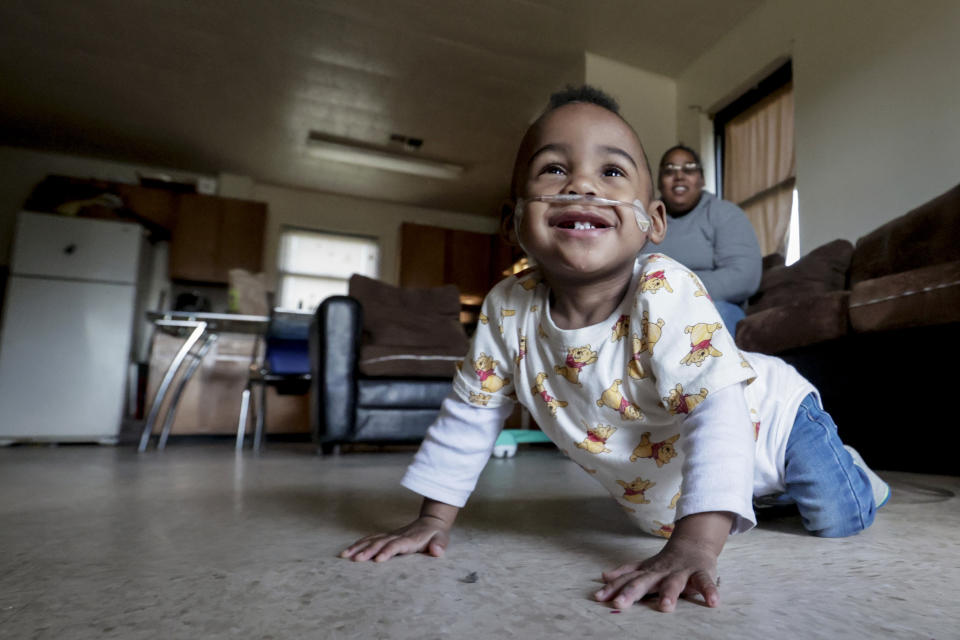 Curtis Means crawls around as his mother, Michelle Butler, keeps an eye on him at their home in Eutaw, Ala., on Wednesday, March 23, 2022. Growing numbers of extremely premature infants, like Curtis, are getting life-saving treatment and surviving. (AP Photo/Butch Dill)