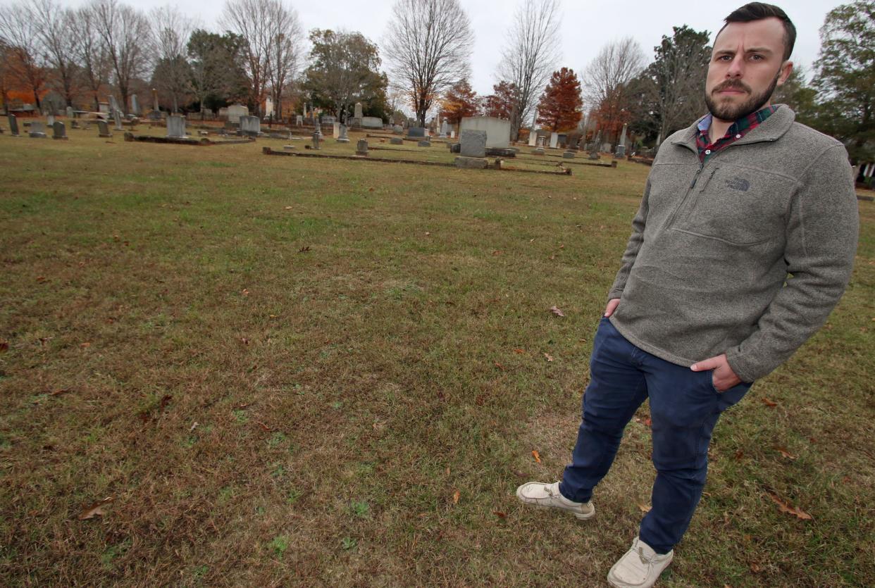 Zach Dressel stands near where unmarked graves are at Sunset Cemetery on West Sumter Street in Shelby.