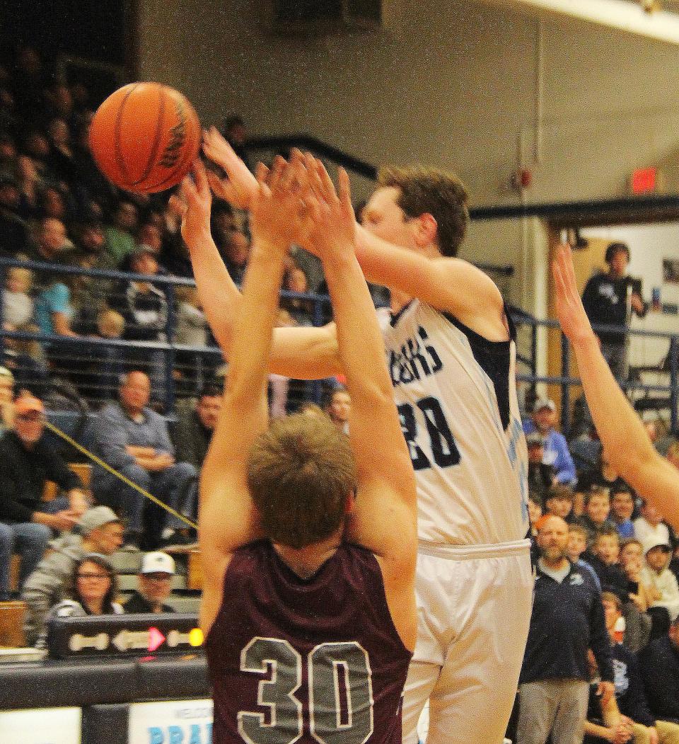 Camden Palmore dishes off for Prairie Central as Austin Langendorf tries to defend Friday.