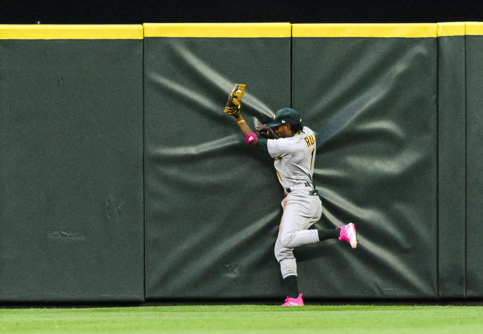 Oakland Athletics' Esteury Ruiz collides with the outfield wall while catching a ball hit by Seattle Mariners' Julio Rodriguez during the fifth inning of a baseball game Tuesday, May 23, 2023, in Seattle. (AP Photo/Caean Couto)