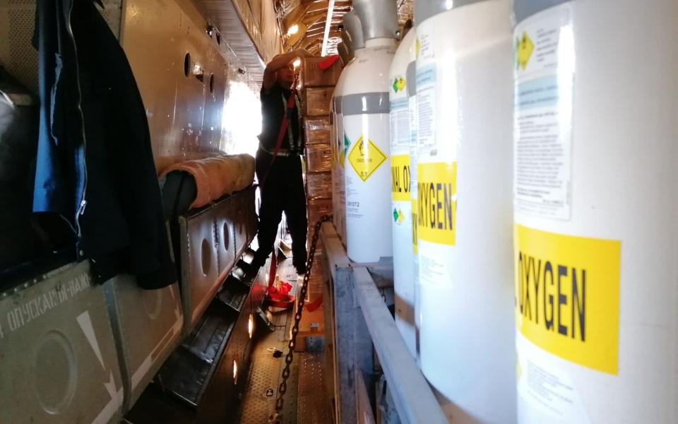 A crew member straps in the cargo of medical oxygen and ventilators on a plane bound for Delhi, India,  - AFP