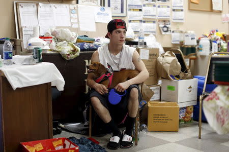 Evacuated resident Raymond Padilla, of Cache Creek, sits with his dog at the Moose Lodge during the Rocky Fire near Clearlake, August 5, 2015. REUTERS/Stephen Lam