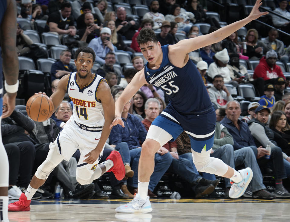 Denver Nuggets guard Ish Smith, left, drives past Minnesota Timberwolves center Luka Garza during the second half of an NBA basketball game Tuesday, Feb. 7, 2023, in Denver. (AP Photo/David Zalubowski)