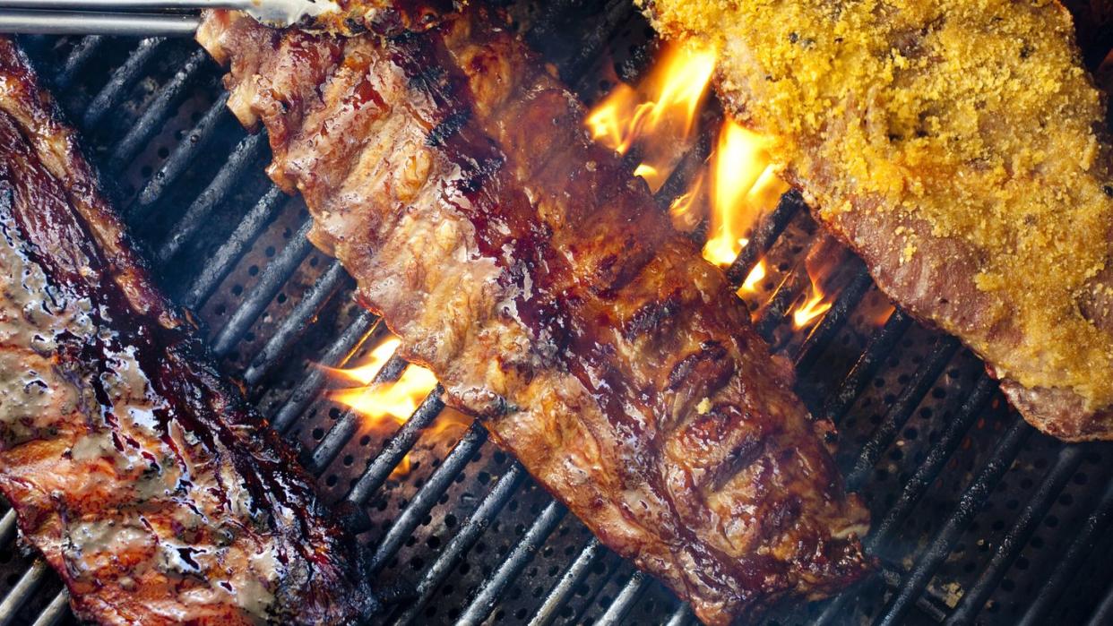 barbequed baby back pork ribs cooking on the grill