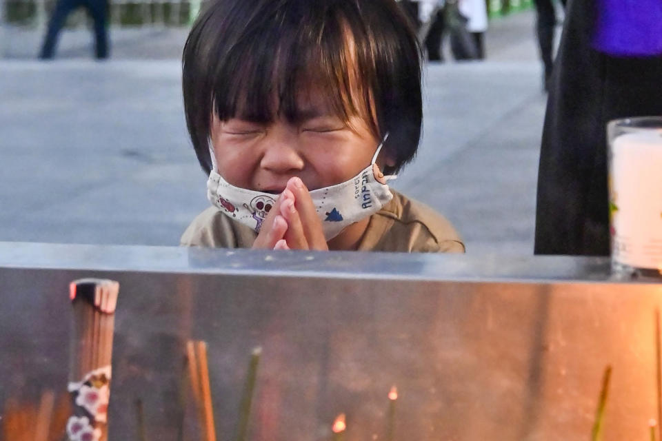 A child prays in front of the cenotaph dedicated to the victims of the atomic bombing at the Hiroshima Peace Memorial Park in Hiroshima, western Japan Friday, Aug. 6, 2021. Hiroshima on Friday marked the 76th anniversary of the world's first atomic bombing of the city. (Kyodo News via AP)